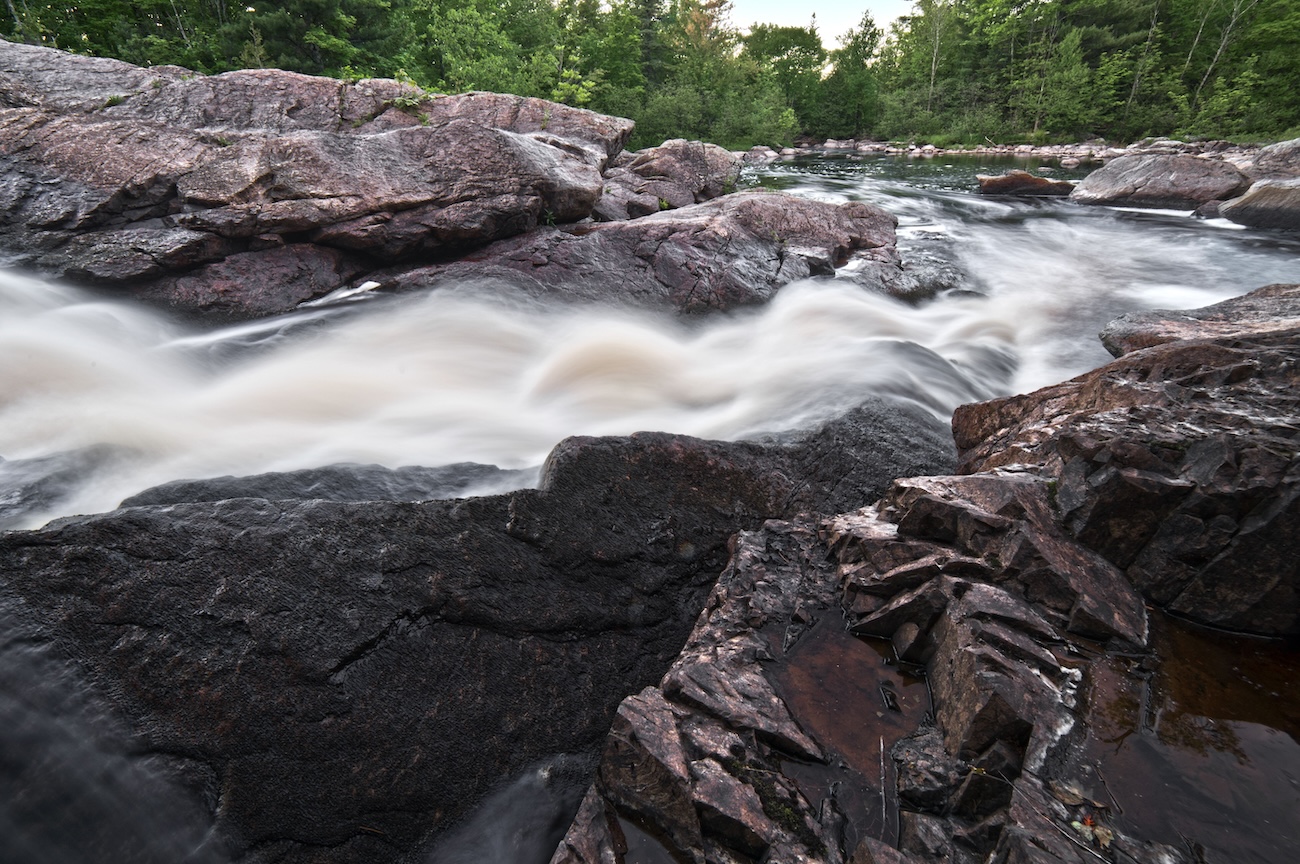 Close-up of water flowing over granite at Oxtongue River Rapids